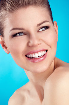 Close-up of pretty blue eyed woman showing healthy white teeth