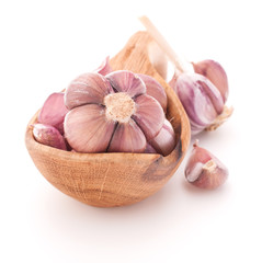 Garlic cloves in wooden bowl isolated on white background