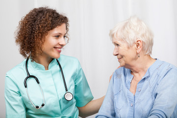 Smiling nurse and happy elderly lady