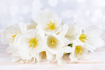 Fototapeta na wymiar Beautiful bouquet of white tulips on table on light background