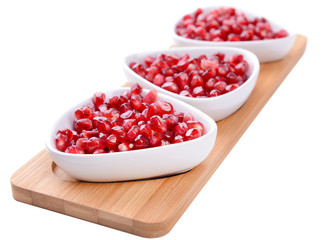 Ripe pomegranate in bowls isolated on white