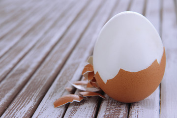 Peeled boiled egg on wooden background