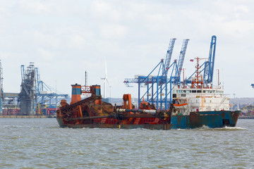 Container ship sailing up the Thames river. Importation.