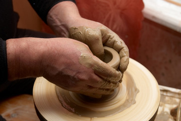 Hands forming clay pot