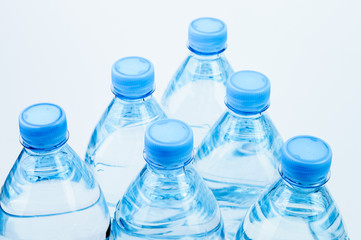 Six water bottles with blue caps