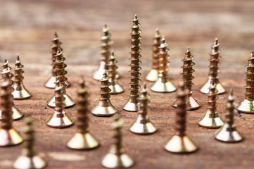 Golden screws on a wooden surface