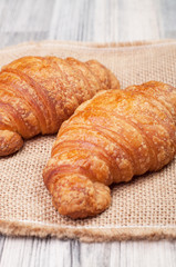 Two croissants on a tablecloth