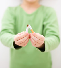 Young girl is breaking a cigarette