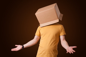 Young man gesturing with a cardboard box on his head