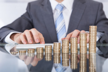 Businessman With Keyboard And Coin Stack