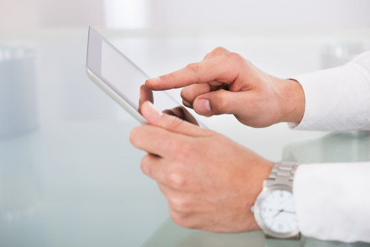 Cropped image of businessman's hands using digital tablet