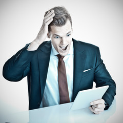 Überraschter junger Manager mit Touchpad