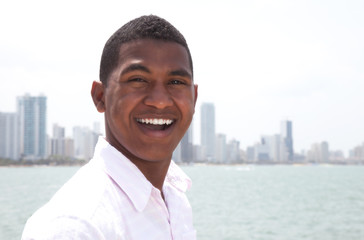 Portrait of a laughing guy at beach with skyline