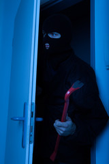 Thief Holding Crowbar While Entering Into House