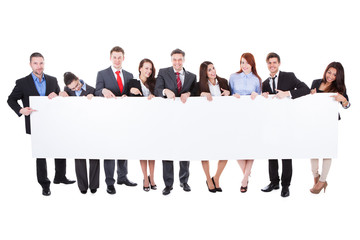 Large group of businesspeople presenting banner