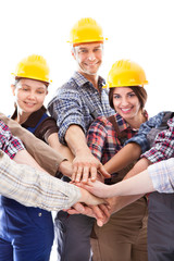 Diverse group of construction workers stacking hands