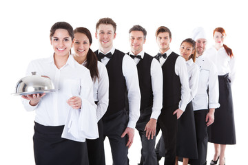 Large group of waiters and waitresses standing in row