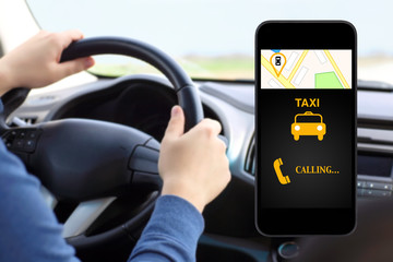 phone with interface taxi on a screen on a background man drivin