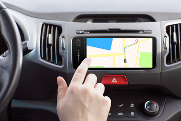 man sitting in a car and touch play finger in a navigation map