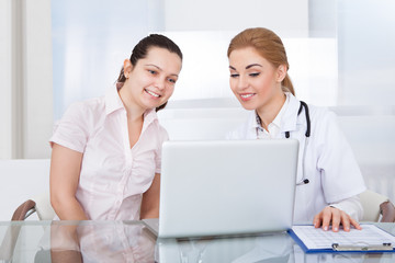 Doctor And Patient Looking At Laptop