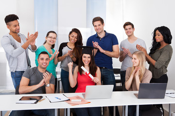 Students Clapping For Classmate Holding Degree