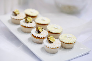 Decorated white vanilla cream cupcakes on a plate