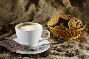 Coffee with milk in a ceramic cup and saucer, refried beans and