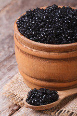 Fototapeta na wymiar black sturgeon caviar in a wooden closeup. Vertical