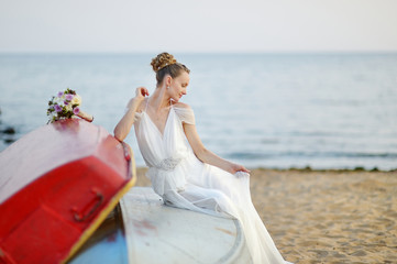 Fototapeta na wymiar Beautiful bride sitting on a boat