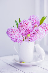 Pink  hyacinths in white vase on white background