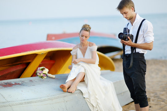 Groom taking a photo of his bride