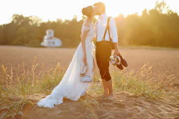Bride and groom on a beach at sunset
