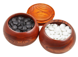 set of go game stones in wooden bowls