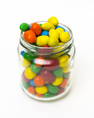 Isolated colorful candy in opened jar on white background.