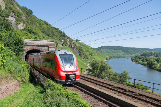 Train leaving a tunnel along river Moselle in Germany