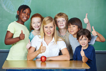 Teacher and students holding thumbs up