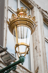 Fototapeta na wymiar Antic royal street lantern on a wall in Brussel, Belgium