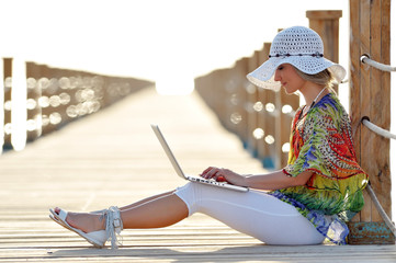 young woman using laptop outdoor in summer