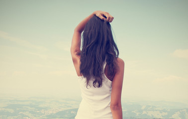 Obraz premium Rear view of standing long hair woman against sky and landscape