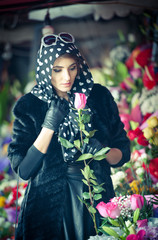 Fototapeta na wymiar Beautiful brunette woman with gloves at florist shop