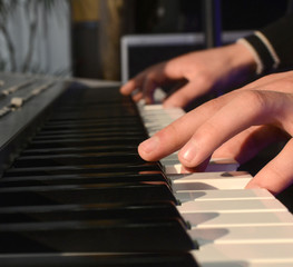 Fototapeta na wymiar Adults fingers on the keys of a piano playing