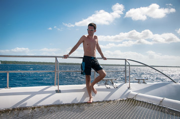 Man holing a rail on a catamaran in the Caribbean Sea