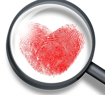 red fingerprint in heart shape through magnifying glass Stock