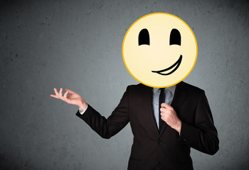 Businessman holding a smiley face emoticon