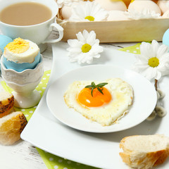 Easter table setting with flowers and eggs on old wooden table
