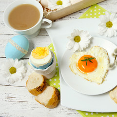 Easter table setting with flowers and eggs on old wooden table