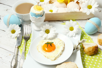 Easter table setting with flowers and eggs on old wooden table