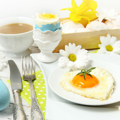 Easter table setting with flowers and eggs on old wooden table