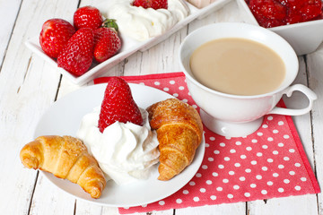 breakfast with croissants, strawberry  and cup of coffe on white