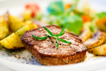 Grilled steak, baked potatoes and vegetables